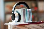 Ein Stapel von Musik-CDs trägt einen schwarzen Kopfhörer