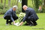 Der Präsident der Bürgerschaft, Peter Paul, und Oberbürgermeister Alexander Badrow legen gemeinsam einen Kranz zum ehrenden Gedenken an die Opfer vor dem Kreuz auf der Gräberstätte ab