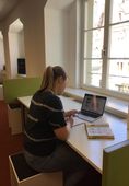 Eine Besucherin der Stadtbibliothek nutzt einen kleinen Arbeitsplatz mit ihrem Laptop
