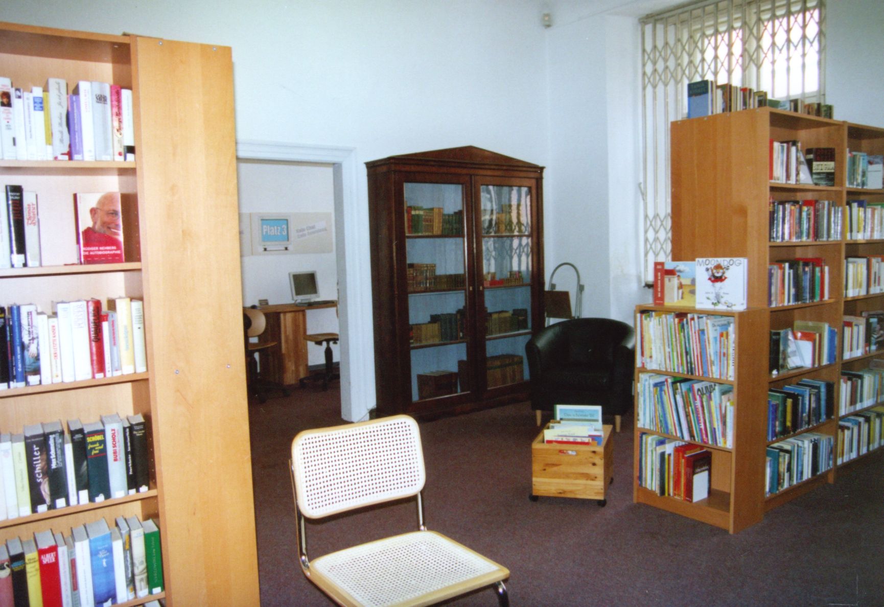 Das Bild zeigt die Bibliothek im Jahr 2006 mit großen Holzregalen und einem alten Schrank.