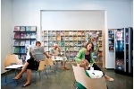 Menschen sitzen im Lesecafé der Stadtbibliothek und Lesen Zeitungen und Zeitschriften