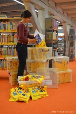 Eine Mitarbeiterin der Kinderbibliothek verpackt Bücher in gelbe Bibliotheksbeutel für die Reisenden Bücher zum Bundesweiten Vorlesetag.