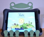 Ein Tablet in einer Hülle in einem Tabletständer, der einem Frosch ähnlich sieht spielt ein Bilderbuch ab