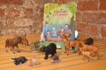 verschiedene Spielfiguren von Waldtieren stehen vor einem Buch mit dem Titel 