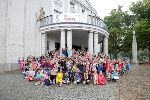 Die ersten Monatsgewinner  des Schuljahres 2022/2023 aus der Montessori-Grundschule „Lambert Steinwich stehen jubelnd und mit Pokal vor dem Theater Vorpommern in Stralsund.